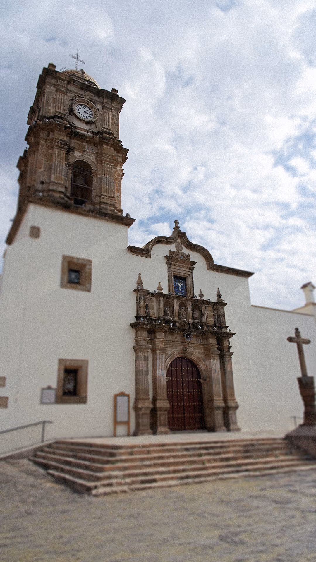 Church facade with stone details and white walls in Amatitán.