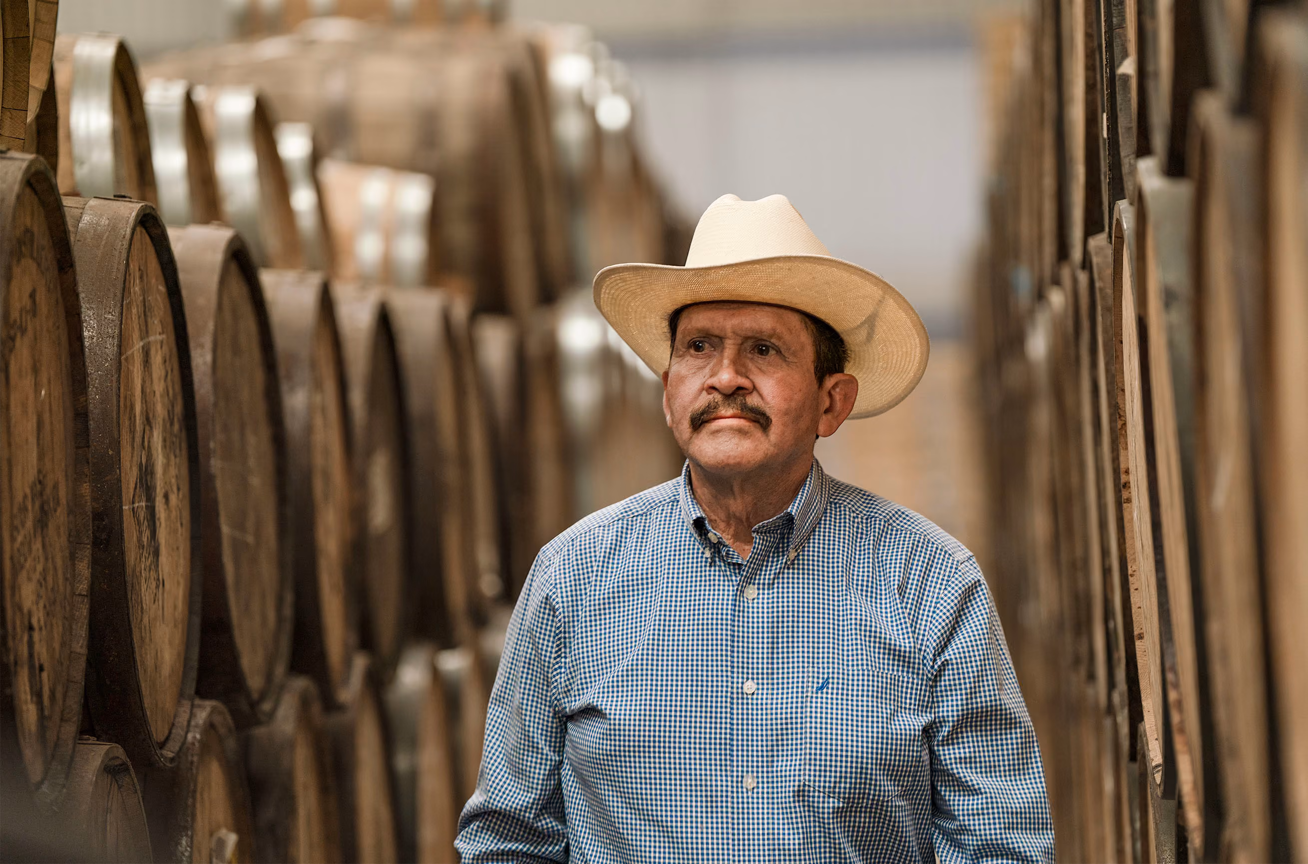 Álvaro Montes among wooden barrels at the distillery.